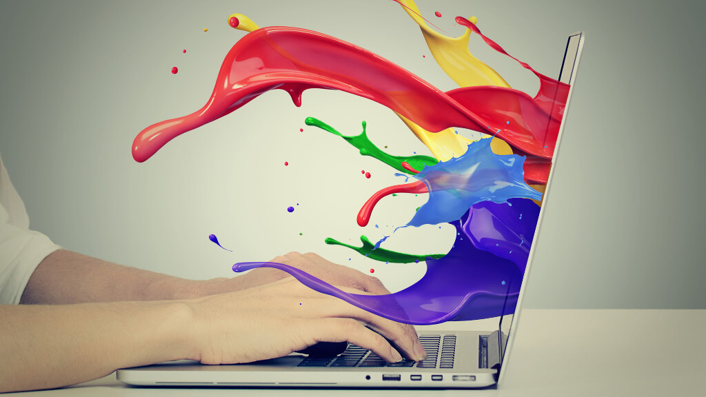 Laptop with paint colors streaming out of it, representing digital creativity.